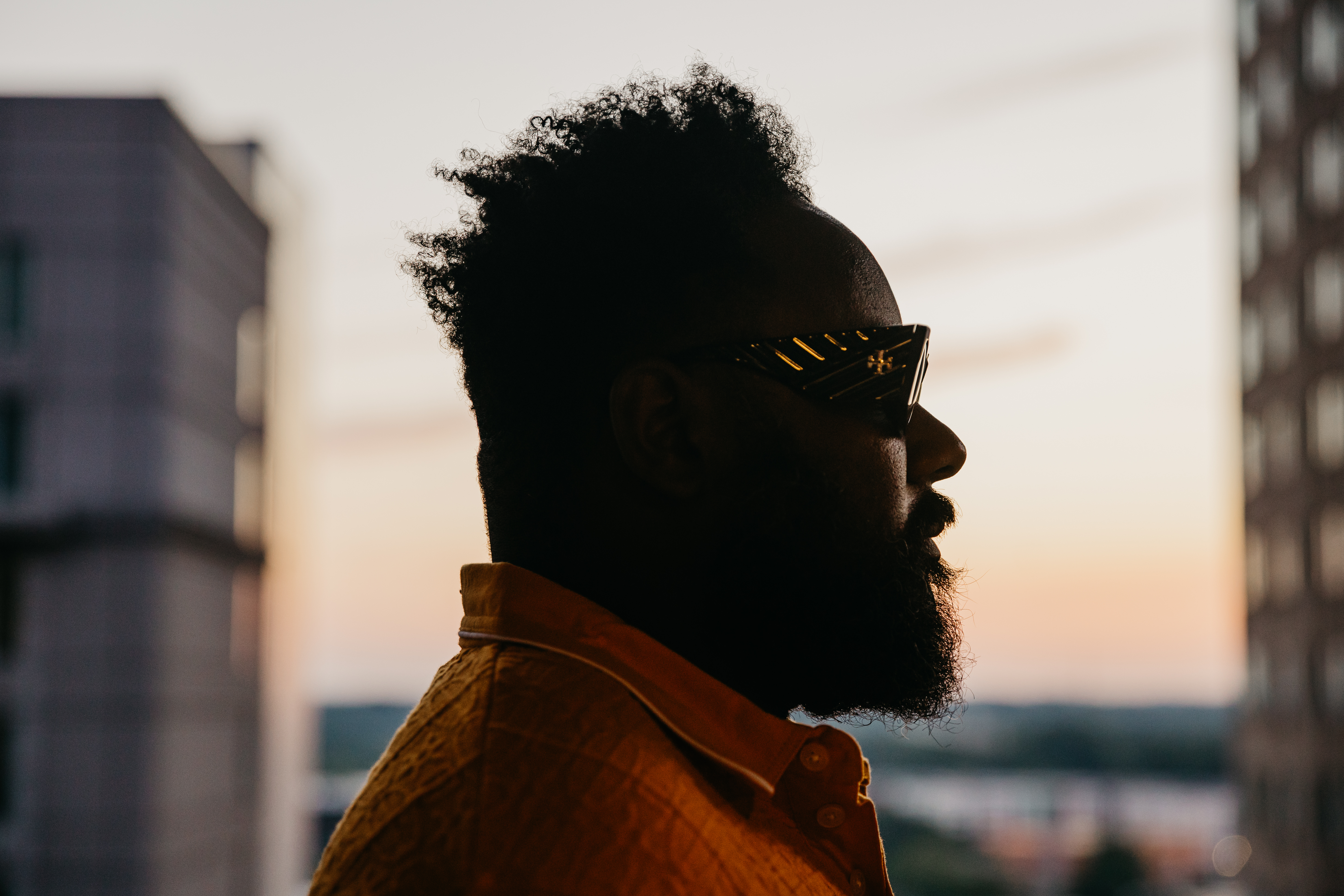 Side profile portrait — Raleigh skyline behind